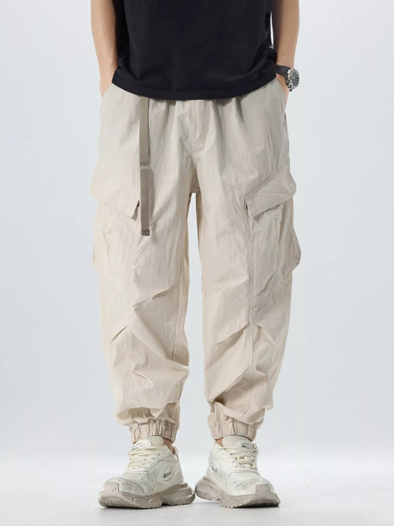 Futuristic beige cargo jogger pants for men, styled with chunky sneakers, modern casual look