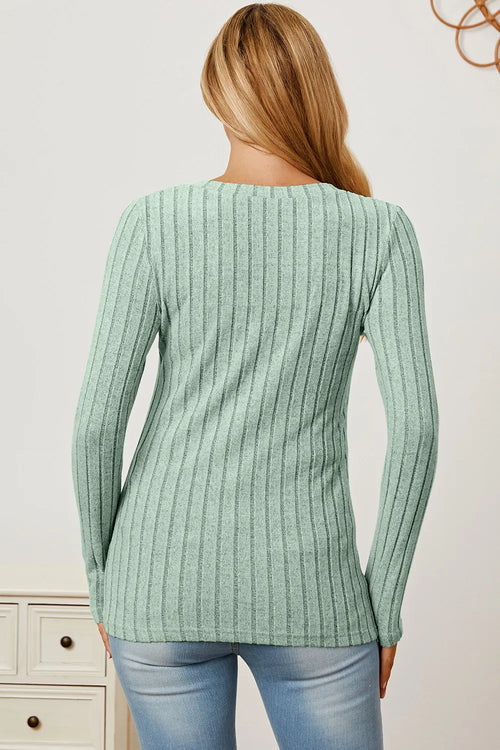 Woman modeling mint green ribbed sweater and light blue jeans, futuristic outfits fashion