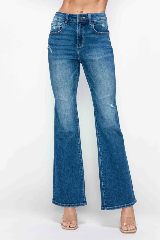 Woman modeling high-waisted flared blue jeans, trendy denim outfit for women